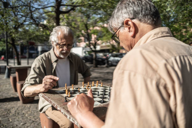 istock Senior friends playing chess in a city square 1860701861