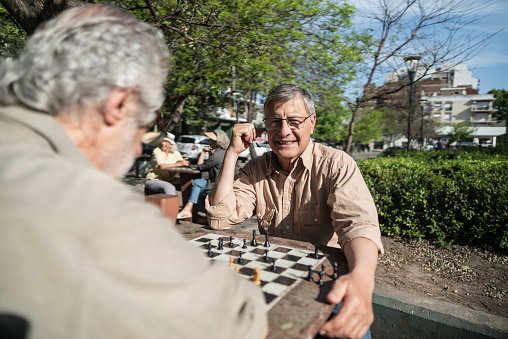 Checkers table in park in Hot Springs, Arkansas with man thinking playing during summer day sitting on bench