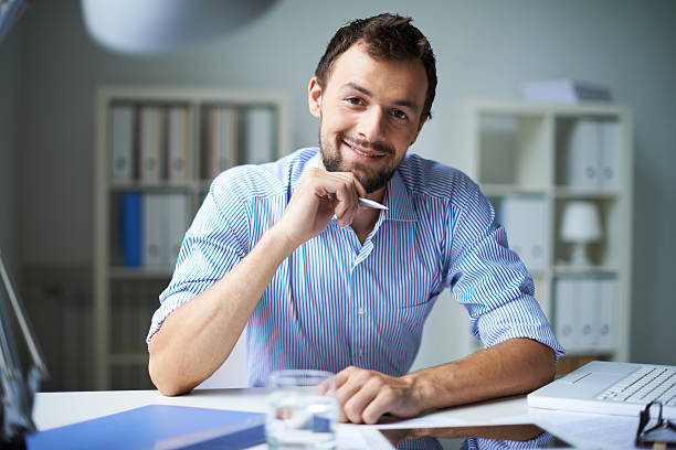 istock Smiling successful businessman working at a desk 186071298