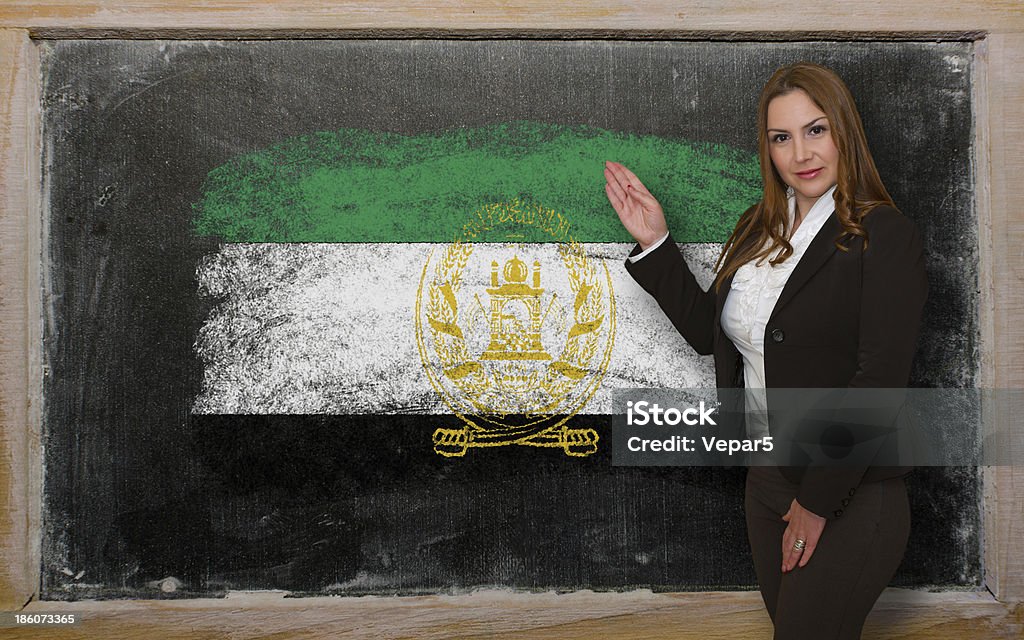 Teacher showing flag of Afghanistan on blackboard for presentation Successful, beautiful and confident woman showing flag of Afghanistan on blackboard for marketing research, presentation and tourist advertising Adult Stock Photo