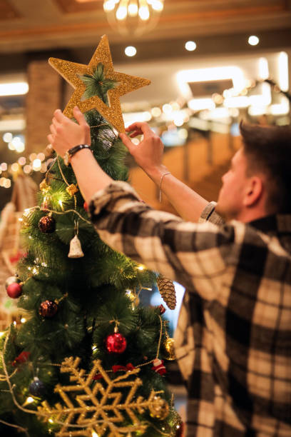 istock Young Man Decorates Christmas Tree, Christmas Gift, Happy New Year 1860774841