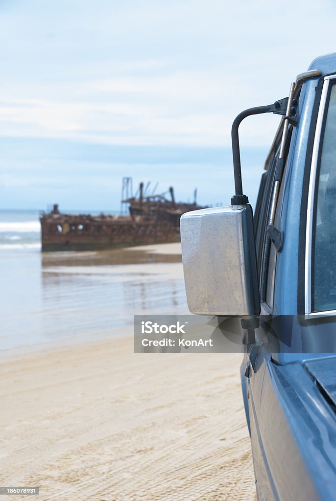 Beach driving and ship wreck Four wheel drive tire on beach covered in sand with ship wreck of Maheno. Beach driving on the world largest sand island called Fraser Isand, Queensland, Australia 4x4 Stock Photo
