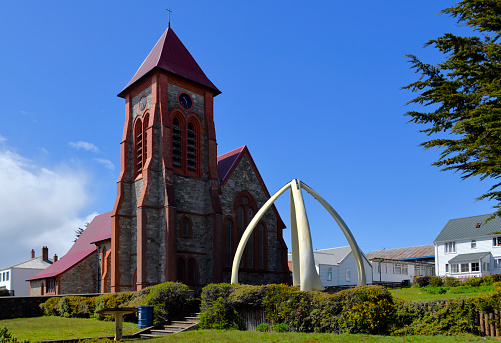 Port Stanley, Falkland Islands: Christ Church Cathedral - parish church of the Falkland Islands, South Georgia and the British Antarctic Territories - southernmost Anglican cathedral in the world. To the right is the whalebone arch, a structure erected in 1933, using the jawbones of two blue whale, it commemorates the centenary of continuous British administration in the Falklands.