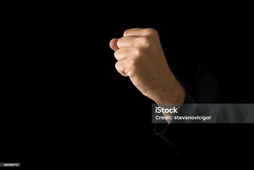 Hand with clenched fist Hand with clenched fist on dark background. Power, determination, resistance concept. Adult Stock Photo