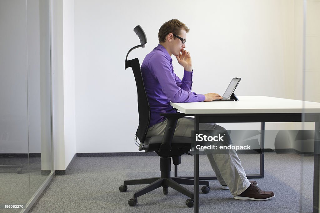 correct sitting position at desk with tablet correct sitting position at desk with tablet in office Ergonomics Stock Photo