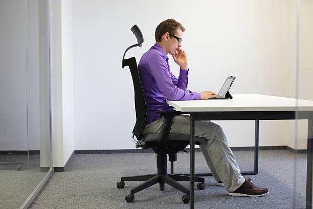 correct sitting position at desk with tablet correct sitting position at desk with tablet in office ergonomics stock pictures, royalty-free photos & images