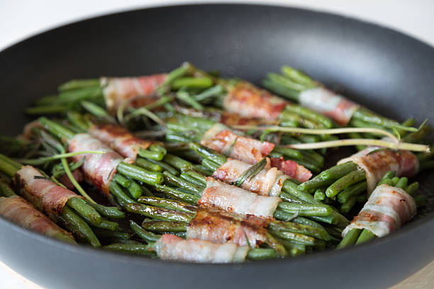 Beans with bacon Beans wrapped in bacon in a pan braising pan stock pictures, royalty-free photos & images