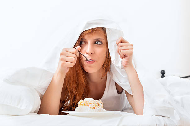 istock woman having sweet cake  at bed 186085216