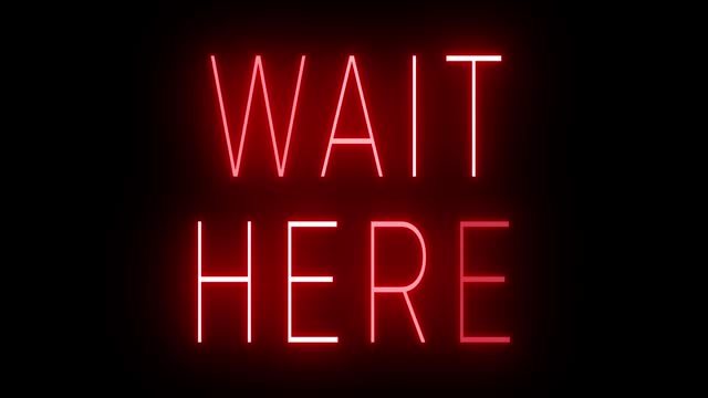 Glowing and blinking red retro neon sign for WAIT HERE