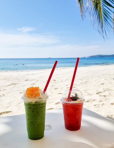 Cold green tea and strawberry shake tropical drinks on the beach of Koh Samet Island Rayong Thailand, Iced Thai Green Milk Tea