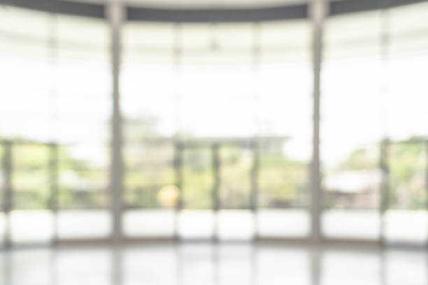 istock Office building lobby hall blur background or blurry school hallway corridor interior view looking toward empty corridor entrance, glass curtain wall and floor with exterior light illumination 1860966210