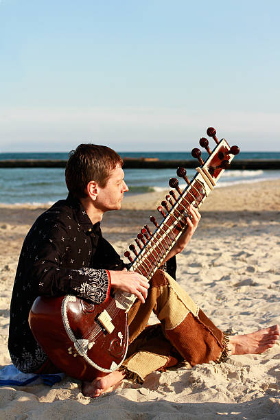 istock Man plays sitar on the beach 186097910