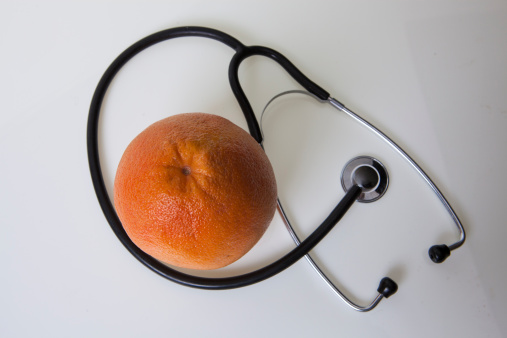 Orange and stethoscope on a white background