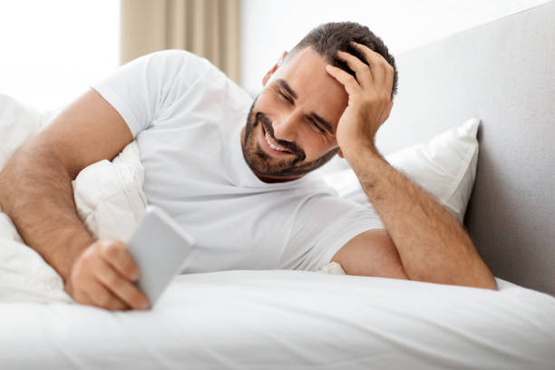 istock man lying in bed and using cellphone sending messages indoor 1861018420