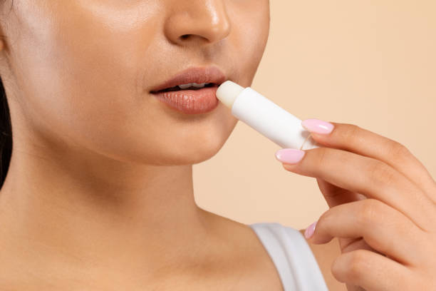 istock Lip Care. Indian Female Using Chapstick To Moisturize Her Beautiful Plump Lips 1861020663