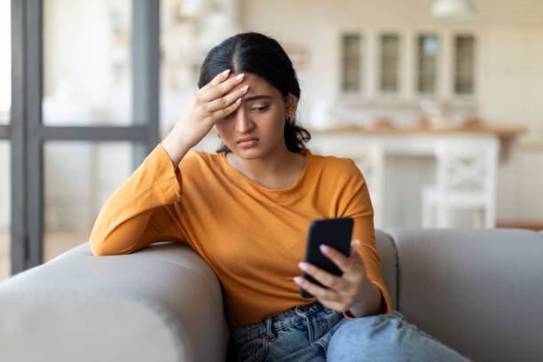 istock Stressed Young Indian Woman Looking At Smartphone Screen And Touching Head 1861021749