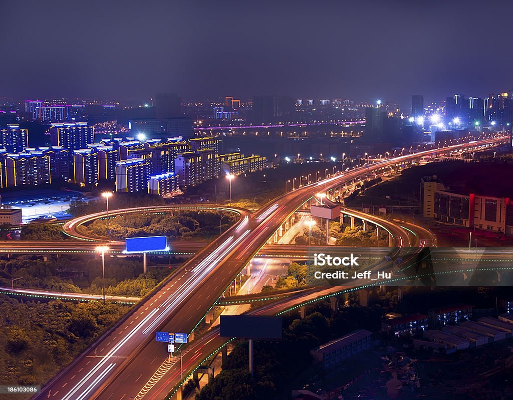 Freeway in night with cars light at modern city Freeway in night with cars light in modern city Bridge - Built Structure Stock Photo