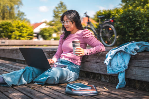 istock Resting Young Female Asian Student Studying on Wooden Platform 1861034375