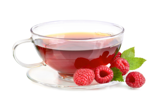 Cup of raspberry tea with fresh berries on white background