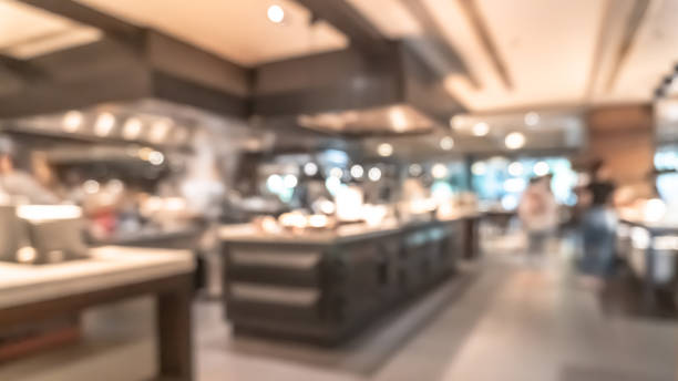 istock Buffet at hotel restaurant interior blur background with blurry open kitchen counter bar of food catering service business with chef staff cooking for breakfast, lunch or dinner meal 1861041414