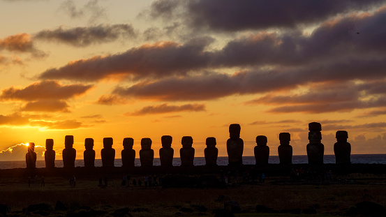The fifteen Moai of Ahu Tongariki at sunrise with a long exposure and colorful clouds on the Easter Island, Chile.