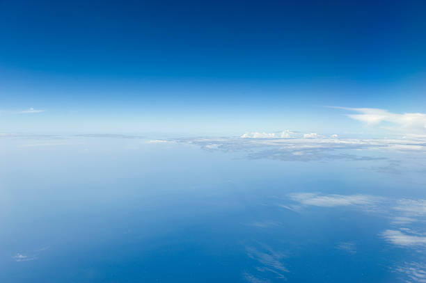 High altitude view of blue sky and clouds. A view of the atmosphere over the sea, taken from a commercial flight. Cirrocumulus stock pictures, royalty-free photos & images