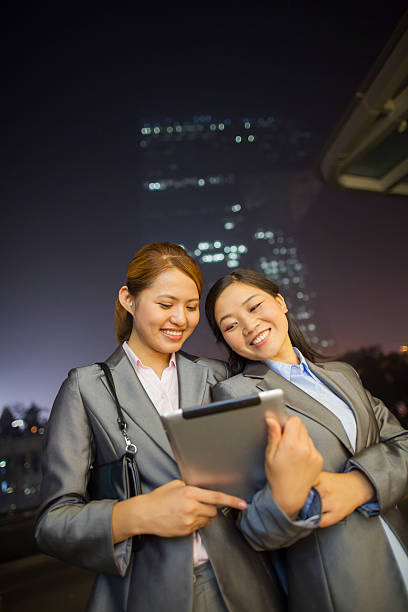 istock Young businesswomen looking at digital tablet and walking 186105777