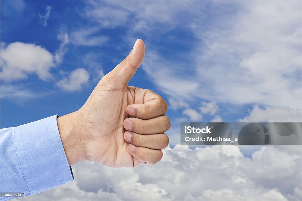 Mano di Uomo d'affari con il pollice in blu cielo nuvoloso - Foto stock royalty-free di Abilità