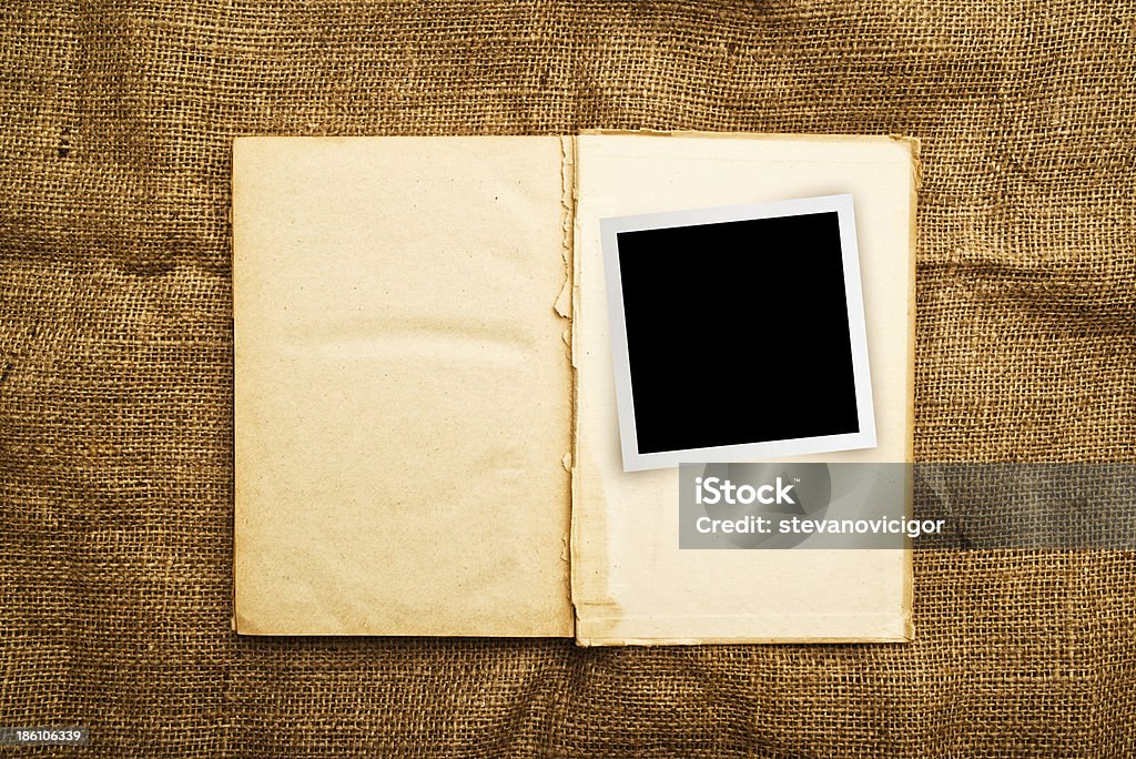 Old open book with photo frame Vintage open book with old grunge paper textured pages and photo frame Blank Stock Photo
