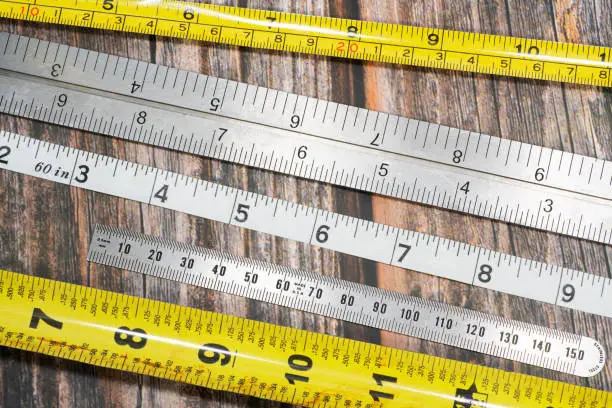 A variety of tape measures on a wooden bench