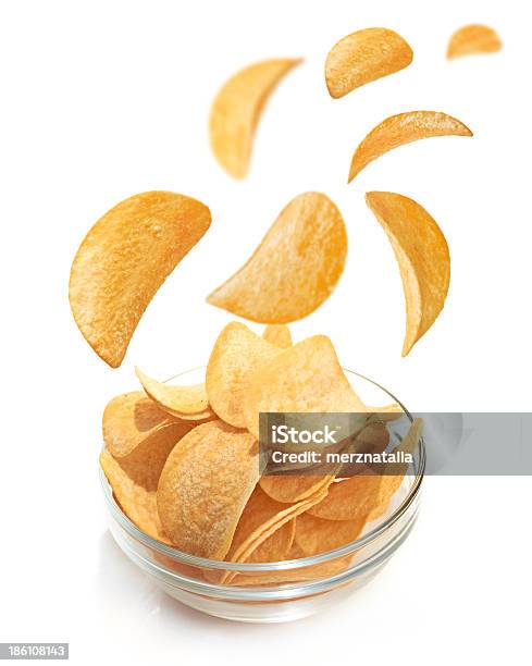 Foto de Tigela De Patato Chips Isolada No Branco e mais fotos de stock de Alimentação Não-saudável - Alimentação Não-saudável, Batata - Tubérculo, Caindo