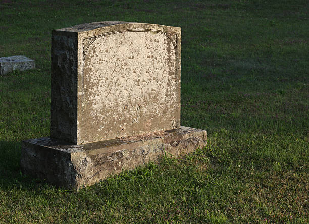 Sun-cast Tombstone A large gravestone in a graveyard, shot in the golden light of dusk. crypt stock pictures, royalty-free photos & images