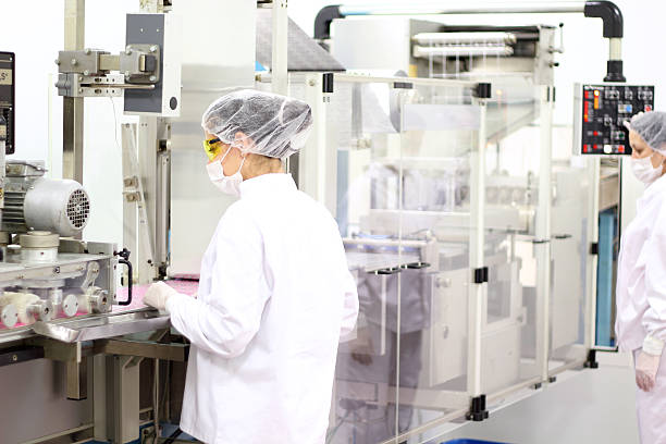 female workers at pharmaceutical factory - farmaceutische fabriek stockfoto's en -beelden