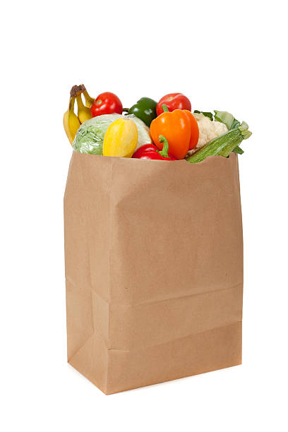 istock Brown grocery sack full of vegetables on white 186109733