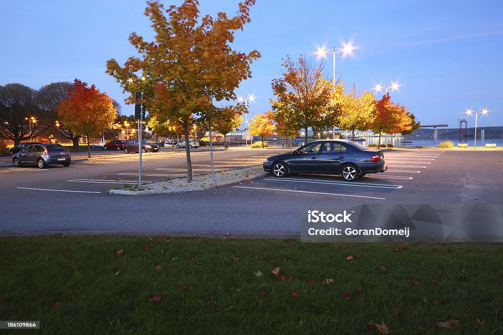 Estacionamiento de una noche de unos vehículos en la luz - Foto de stock de Aparcamiento libre de derechos