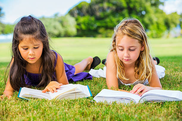 istock Little Girls Reading Books on Grass 186111939