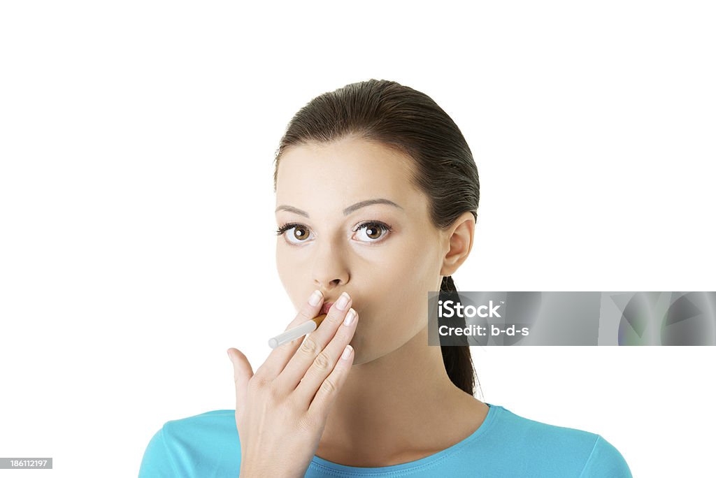 Attractive woman with cigarette in her mouth. Attractive woman with cigarette in her mouth. Isolated on white. Addiction Stock Photo