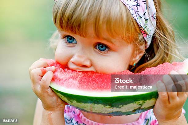 Adorable Little Girl Eats A Slice Of Watermelon Outdoors Stock Photo - Download Image Now