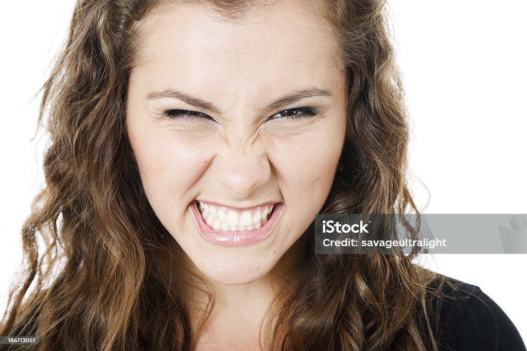 closeup of young female on white closeup of young beautiful female showing teeth looking at camera isolated on white Adult Stock Photo