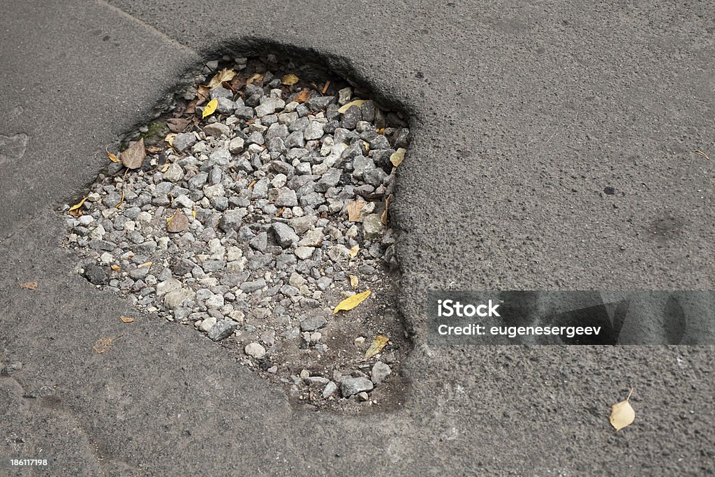 Pothole mit gravel auf beschädigten städtische asphalt road - Lizenzfrei Alt Stock-Foto