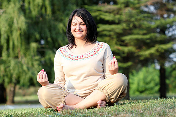 istock beautiful girl meditating in park 186117208