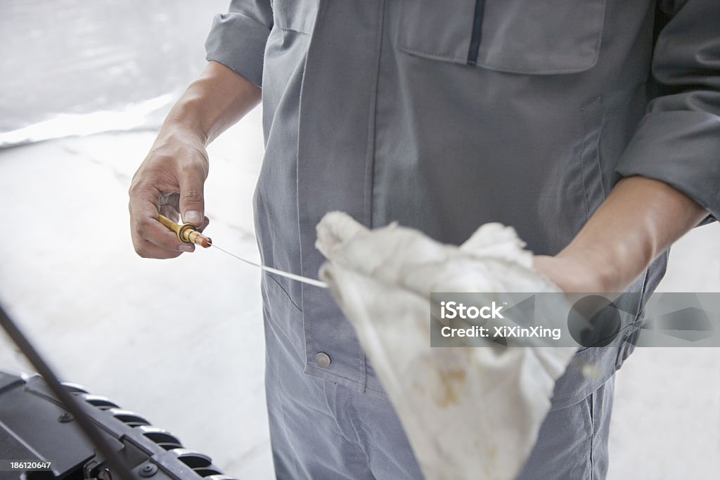 Mécanicien En les essuyant Jauge de niveau d'huile - Photo de Chiffon libre de droits