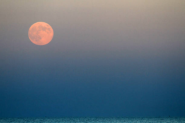 istock Red Moon that rises above the blue sea 186120974
