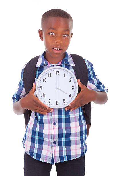 istock African American school boy holding a clock - Black people 186122194