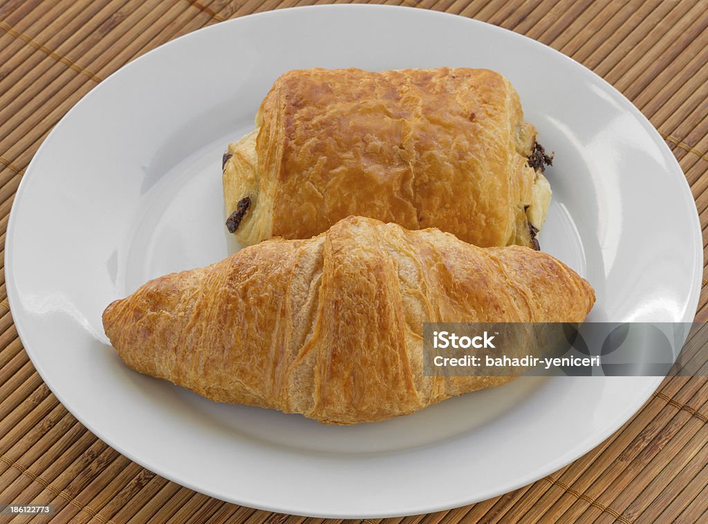 Croissant and Pain au Chocolat A Croissant and a Pain au Chocolat on a White Plate Baked Pastry Item Stock Photo