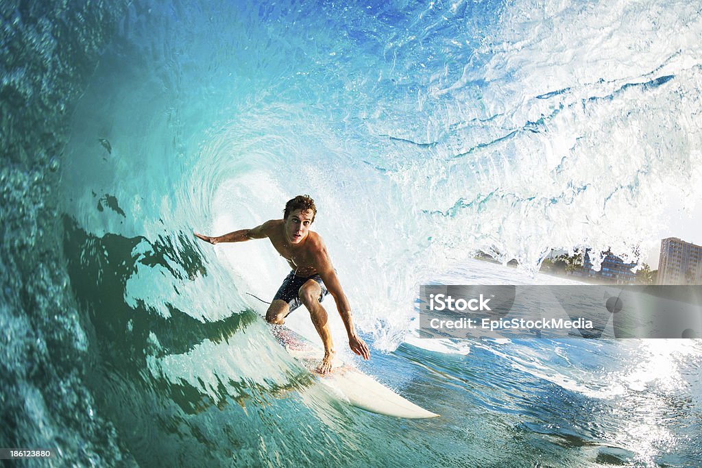 Close-up of a surfer riding a large blue wave Surfer on Blue Ocean Wave in the Tube Getting Barreled Surfing Stock Photo