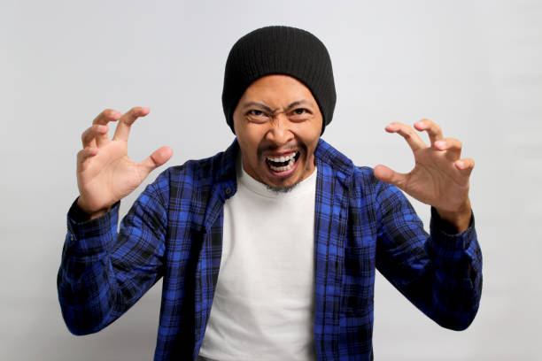 istock Angry young Asian man is shouting with his arm raised 1861250719