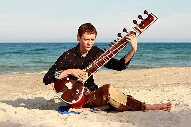 istock Musician is playing sitar on the beach 186127838