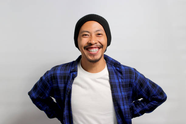 istock Confident young Asian man stands with arms akimbo while standing against white background 1861283137