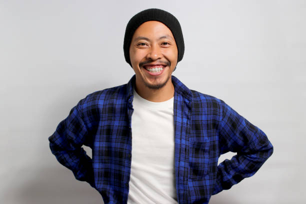 istock Confident young Asian man stands with arms akimbo while standing against white background 1861283138